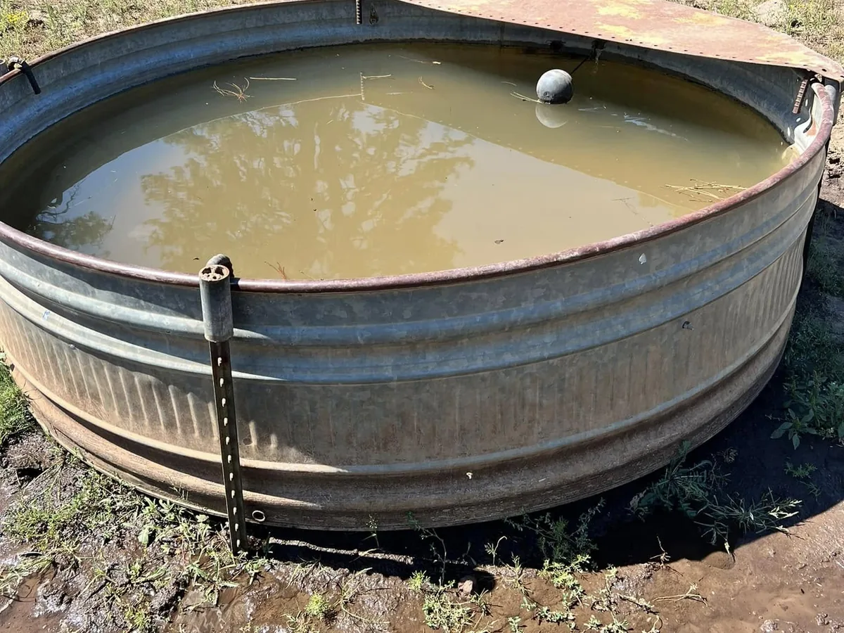 Galvanized stock tank filled with water and fitted with a float valve