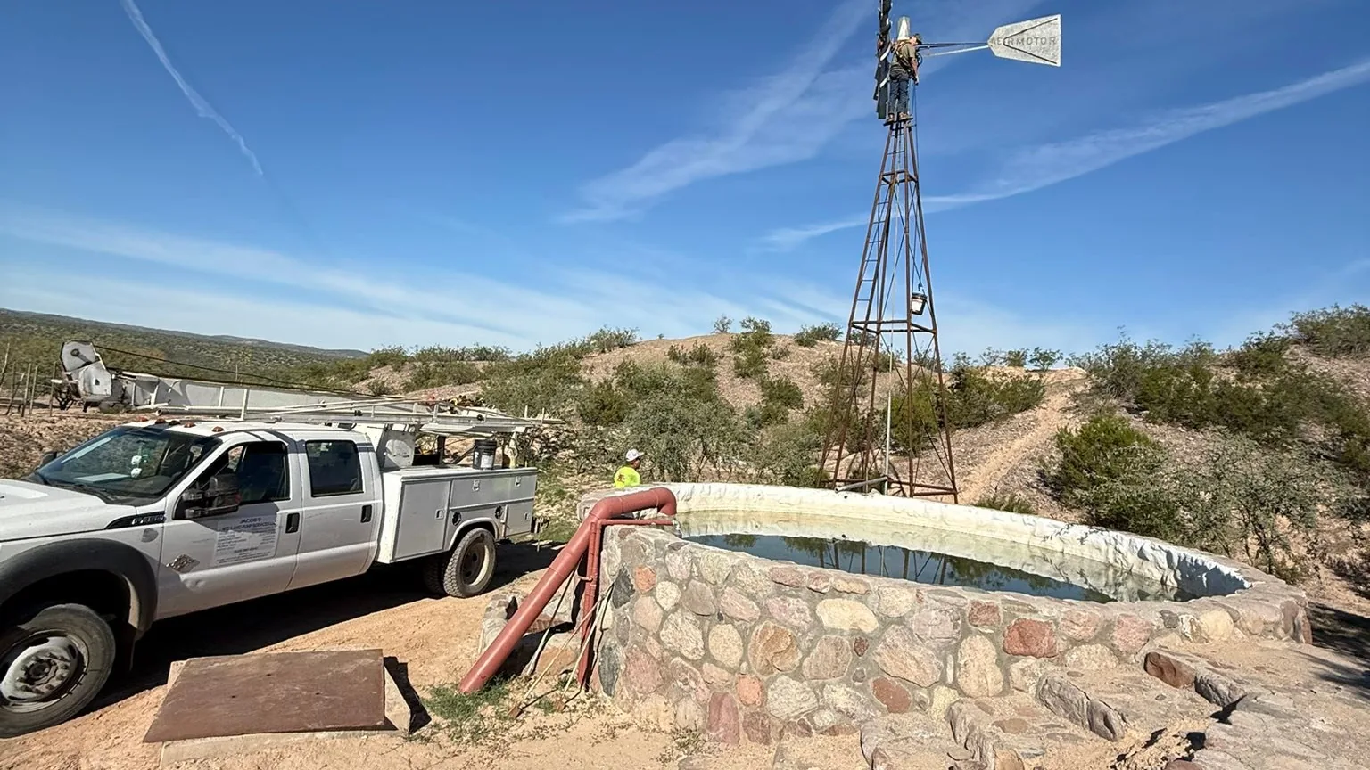 Windmill and well service truck at a stock tank in the Mammoth area of Arizona
