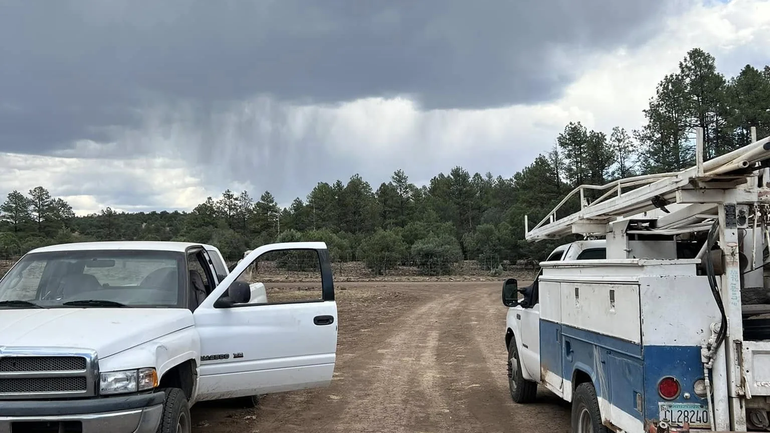 Service trucks parked on a back road in Arizona pine country on the way to a well job