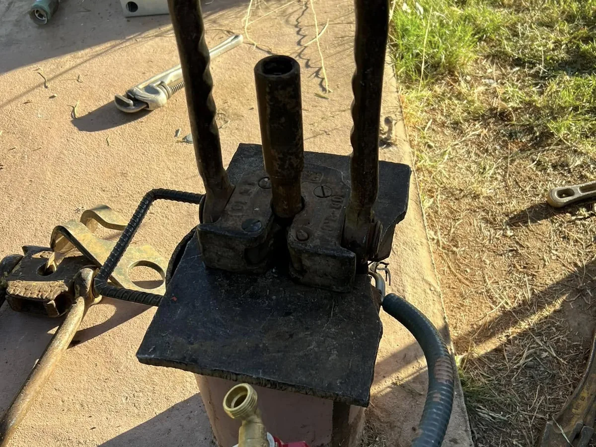 Finished wellhead plumbed on its concrete pad with discharge line and valve
