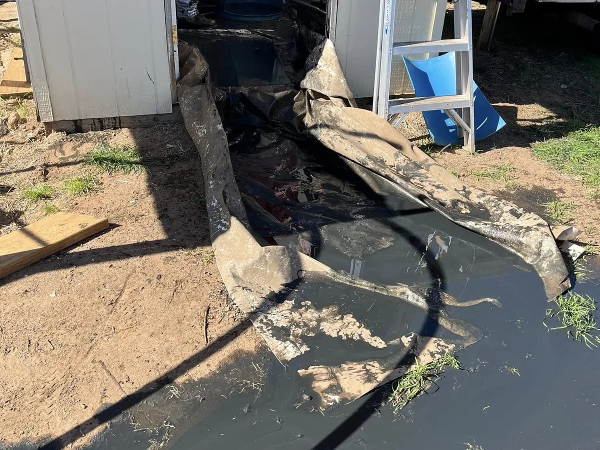 Sediment bailed out of a well and dumped on a tarp beside the well house