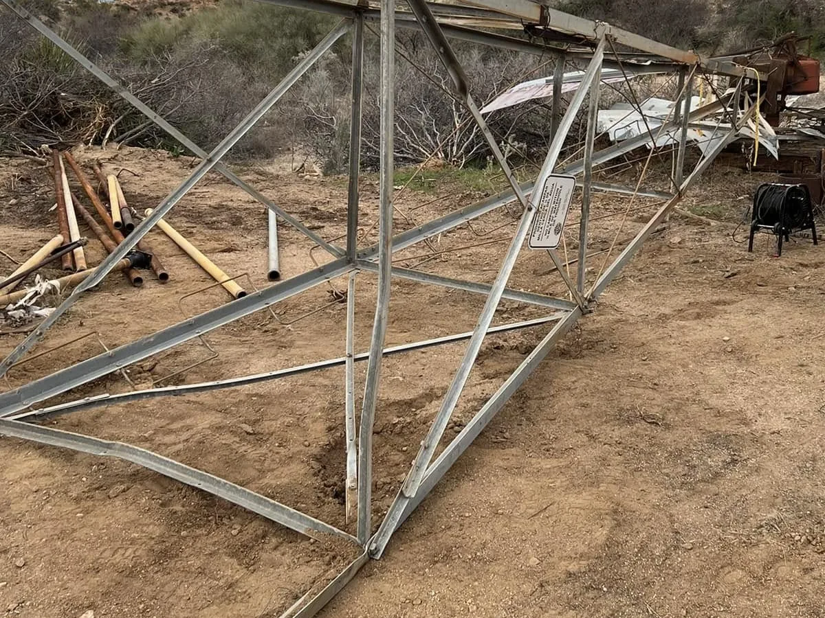 Windmill laid down on the ground with its tower legs apart for repair